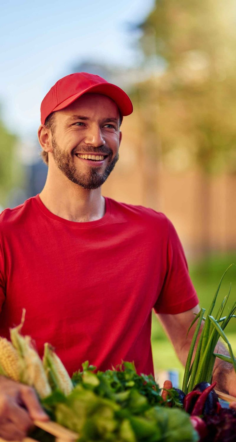 young-happy-caucasian-male-courier-delivering-groc-X2PBW5S.jpg